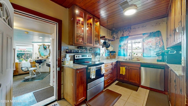 kitchen with light tile patterned floors, sink, stainless steel appliances, wooden ceiling, and light stone countertops