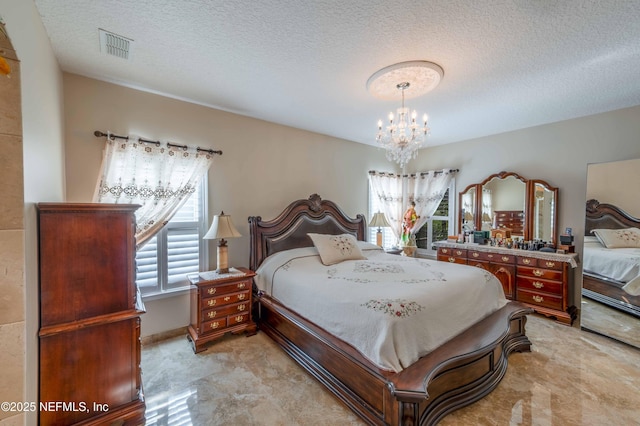 bedroom featuring a chandelier, visible vents, and a textured ceiling