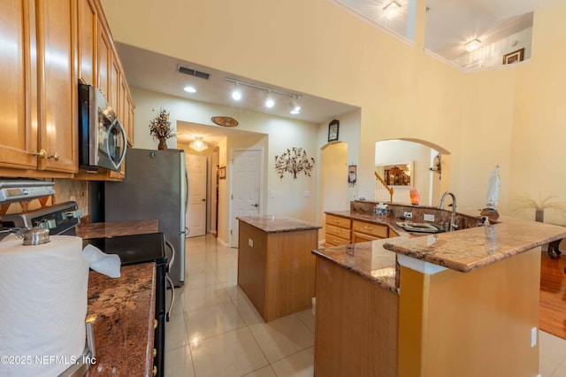 2518 Willow Creek Dr, Fleming Island, FL 32003 - kitchen with stainless steel microwave, a kitchen island, range, arched walkways, and a sink
