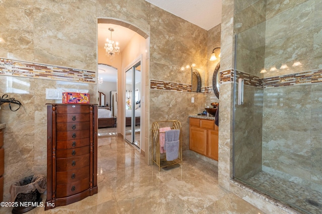 2518 Willow Creek Dr, Fleming Island, FL 32003 - bathroom with marble finish floor, connected bathroom, tile walls, a shower stall, and vanity