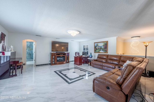 2518 Willow Creek Dr, Fleming Island, FL 32003 - living area featuring baseboards, a chandelier, arched walkways, marble finish floor, and a textured ceiling