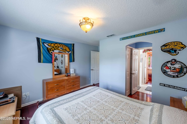 2518 Willow Creek Dr, Fleming Island, FL 32003 - bedroom with visible vents, baseboards, wood finished floors, arched walkways, and a textured ceiling