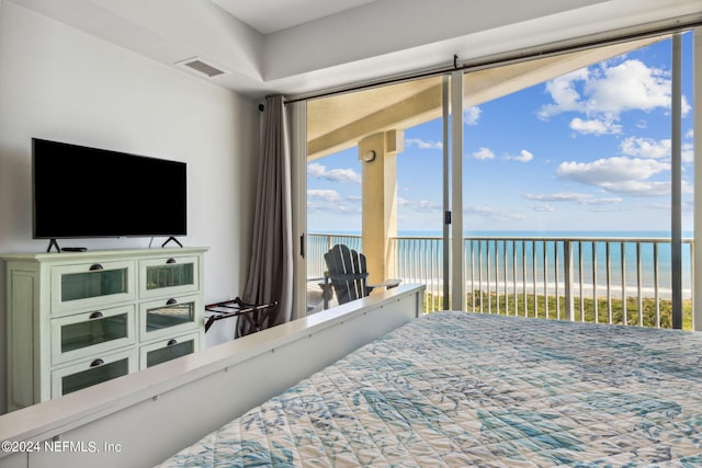 bedroom with a beach view, access to exterior, and a water view