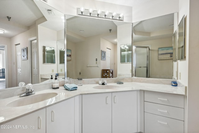 bathroom featuring vanity and a shower with shower door