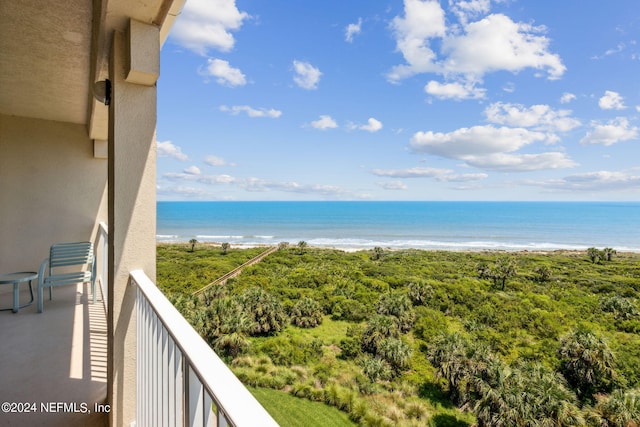 balcony with a water view and a view of the beach