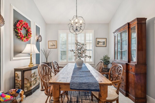 dining space with plenty of natural light, vaulted ceiling, a notable chandelier, and light tile patterned floors