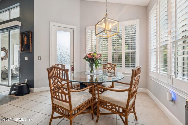 dining room featuring lofted ceiling, a wealth of natural light, a notable chandelier, and light tile patterned flooring