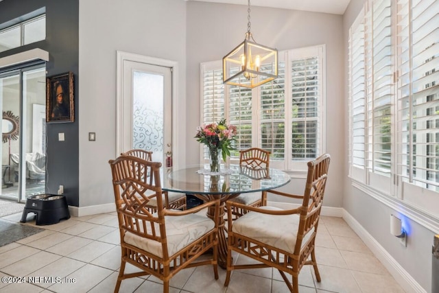 dining room featuring a notable chandelier, baseboards, and light tile patterned floors