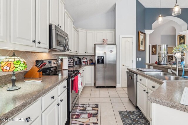 kitchen with white cabinetry, lofted ceiling, stainless steel appliances, and sink