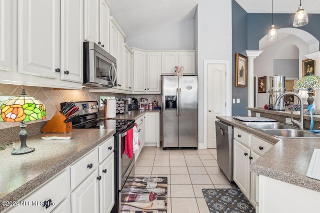 kitchen with light tile patterned floors, stainless steel appliances, decorative backsplash, white cabinetry, and a sink