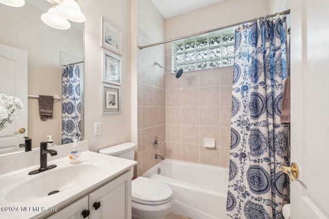 bathroom featuring toilet, shower / tub combo with curtain, and vanity