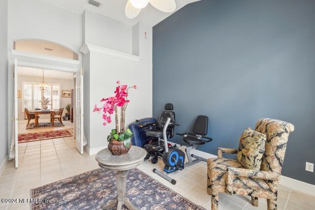 living area featuring lofted ceiling, ceiling fan, and light tile patterned floors