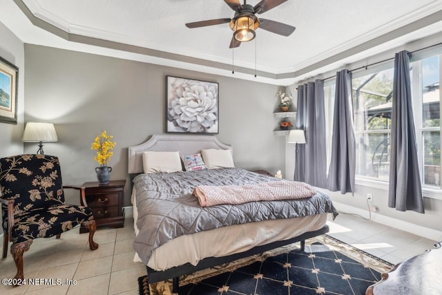 tiled bedroom with a tray ceiling, ceiling fan, and ornamental molding