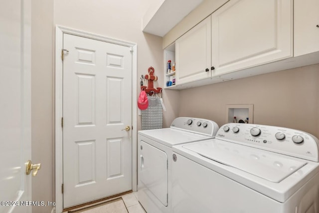 laundry room featuring cabinets, light tile patterned floors, and washing machine and dryer