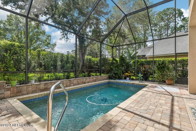 view of swimming pool featuring a lanai and a patio