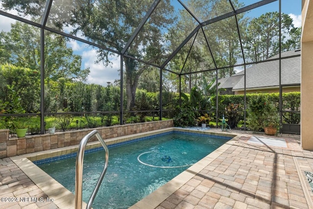 pool featuring glass enclosure and a patio area