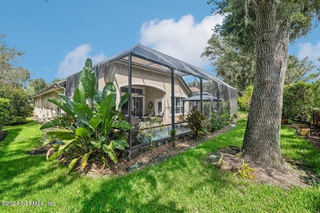 back of house with a yard and glass enclosure