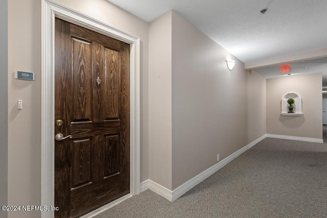 entryway featuring a textured ceiling and carpet flooring