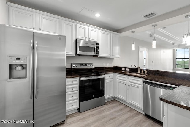 kitchen with white cabinets, hanging light fixtures, stainless steel appliances, and sink