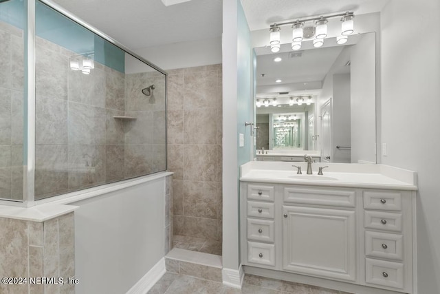 bathroom with tile patterned floors, tiled shower, and vanity