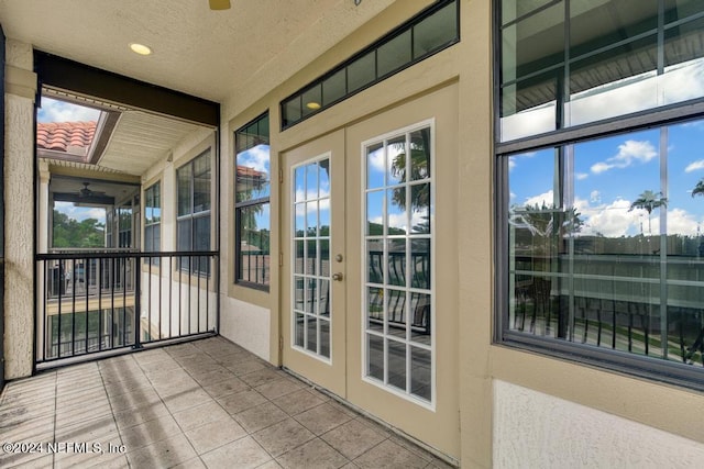 unfurnished sunroom with a healthy amount of sunlight, beamed ceiling, and french doors