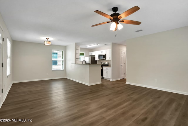 unfurnished living room with dark hardwood / wood-style flooring and ceiling fan