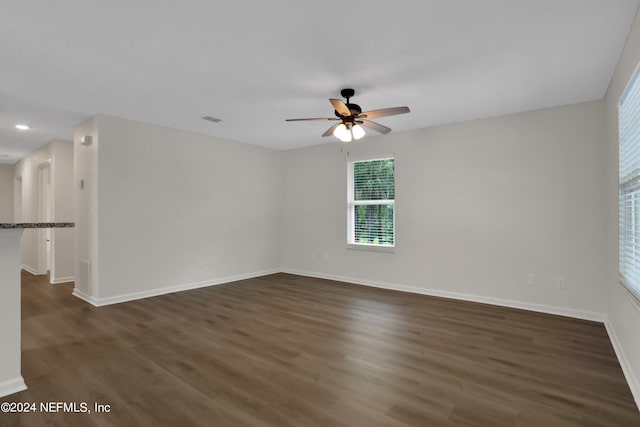 spare room featuring ceiling fan and dark wood-type flooring