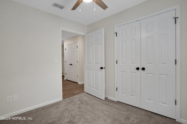 unfurnished bedroom with carpet flooring, ceiling fan, and a closet