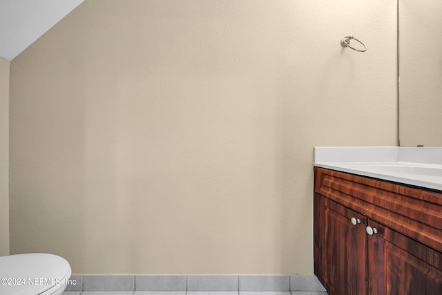 bathroom with vanity, toilet, and vaulted ceiling