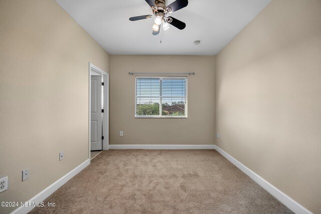 empty room featuring light colored carpet and ceiling fan