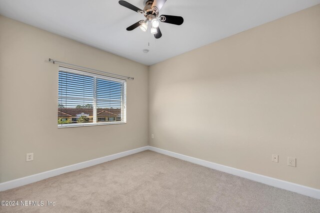 carpeted spare room with ceiling fan