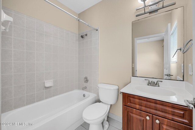 full bathroom with vanity, toilet, tiled shower / bath combo, and tile patterned floors