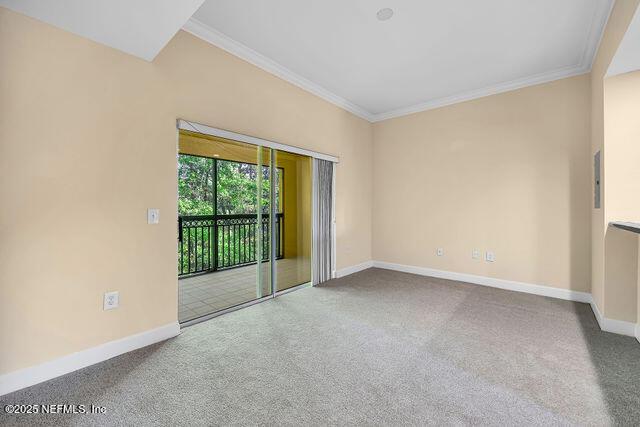 empty room featuring baseboards, ornamental molding, and carpet