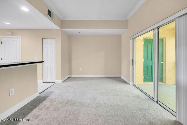 unfurnished room with light colored carpet, ornamental molding, baseboards, and recessed lighting