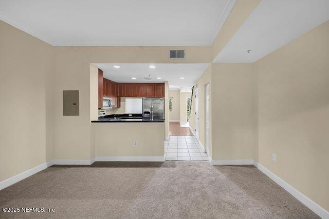 unfurnished living room with electric panel, light carpet, baseboards, and recessed lighting