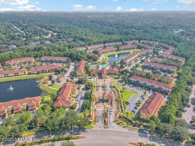 aerial view of property's location with a nearby body of water and a heavily wooded area