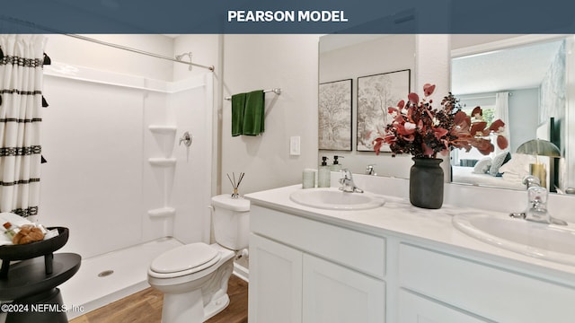 bathroom featuring a shower with shower curtain, wood-type flooring, toilet, and vanity