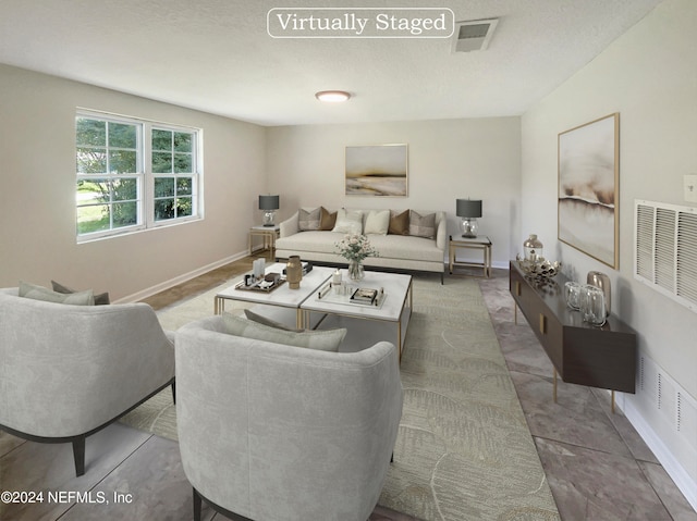 tiled living room featuring a textured ceiling