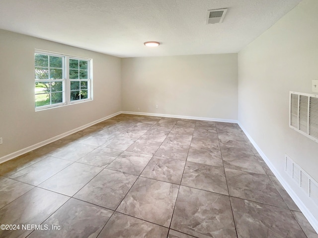 unfurnished room with a textured ceiling