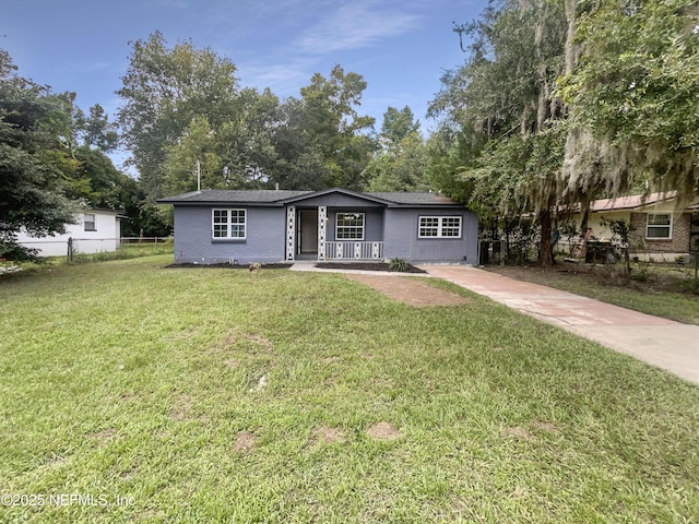 ranch-style house featuring a front yard, brick siding, fence, and driveway