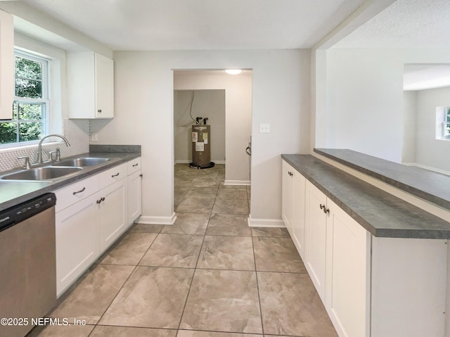 kitchen with a sink, dark countertops, dishwasher, and electric water heater