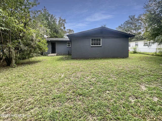 back of house featuring a lawn