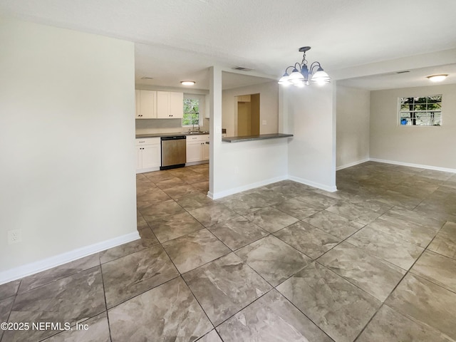 interior space featuring a chandelier, a healthy amount of sunlight, a sink, and baseboards