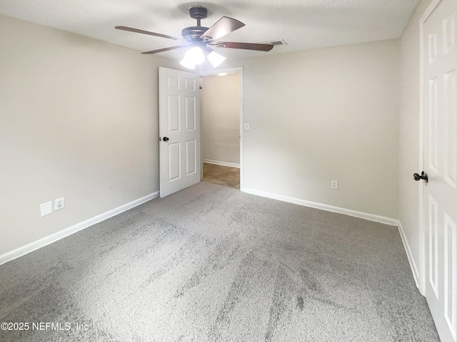 unfurnished bedroom featuring ceiling fan, carpet floors, visible vents, and baseboards