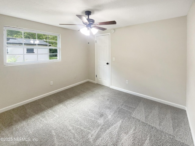 empty room with ceiling fan, baseboards, and carpet flooring