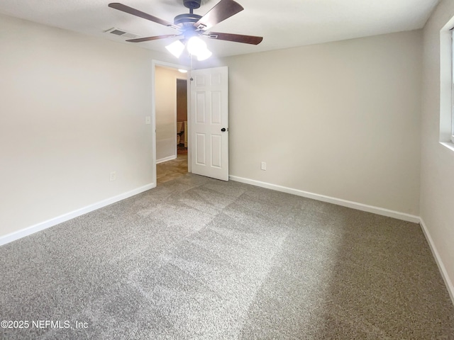 spare room featuring ceiling fan, carpet flooring, visible vents, and baseboards