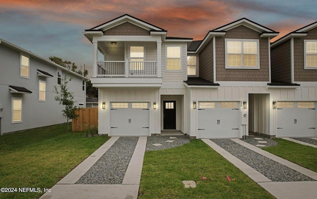 view of front facade featuring a garage, a yard, and a balcony