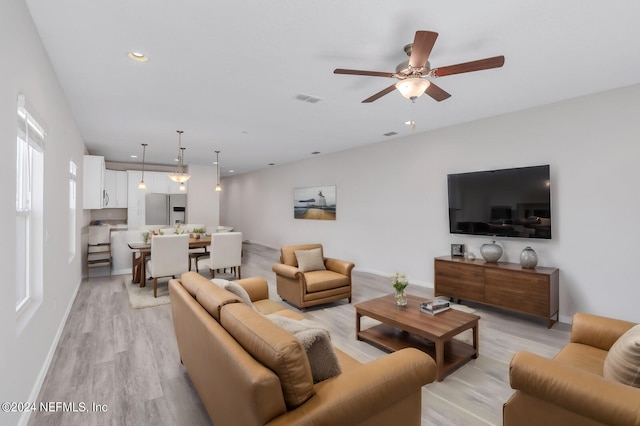 living room with ceiling fan and light wood-type flooring