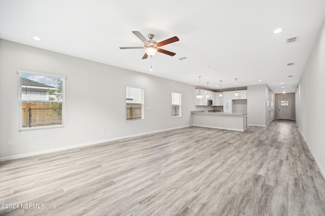 unfurnished living room with ceiling fan and light wood-type flooring