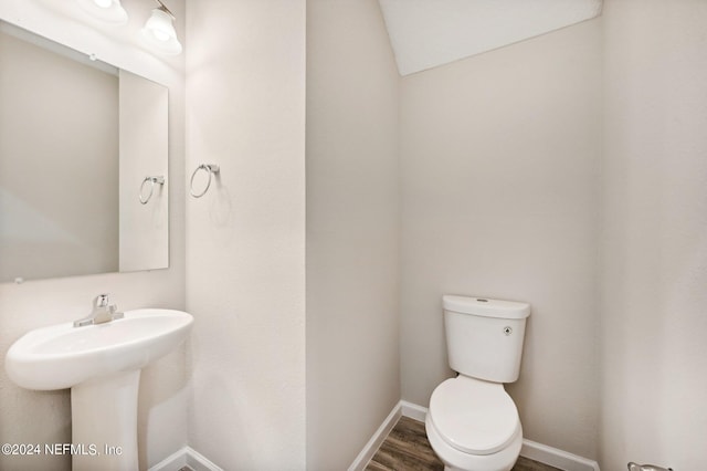 bathroom with hardwood / wood-style floors, toilet, and sink